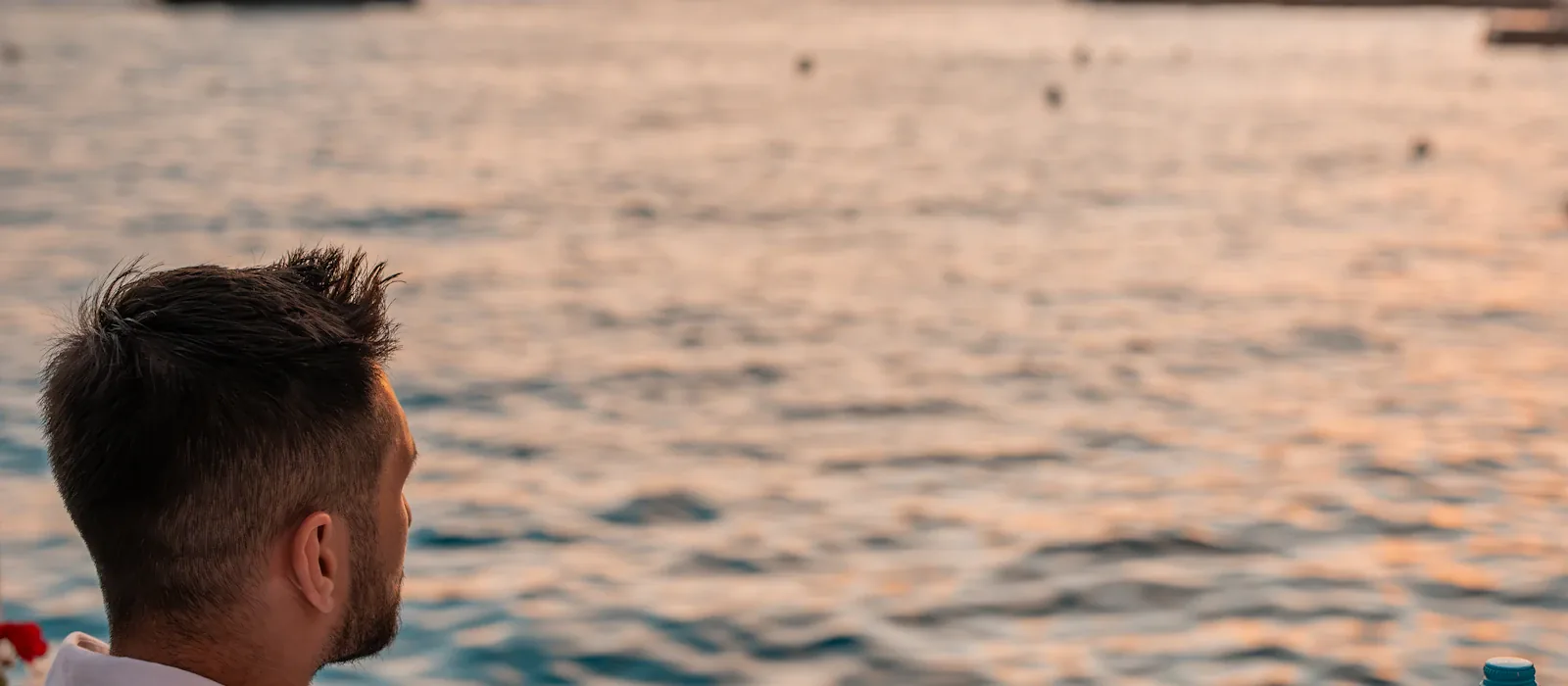 Man dining by the sea at sunset